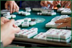 People playing mahjong on a table

AI-generated content may be incorrect.
